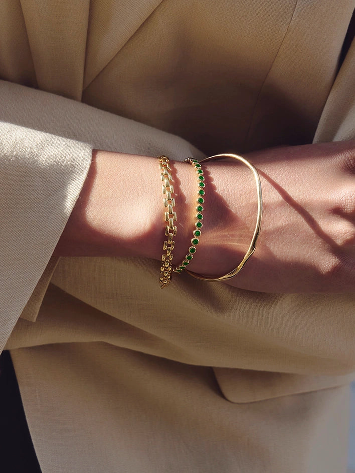 Stacking gold timepiece and tennis bracelets